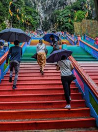 Rear view of people walking on staircase