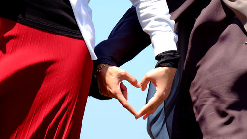 Midsection of couple holding hands