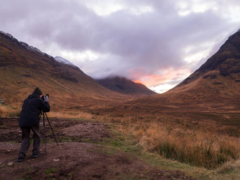 Rear view of man on mountain against sky