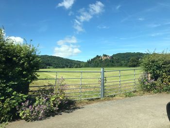 Gate on landscape against sky