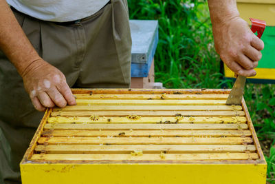 Midsection of man working on cutting board