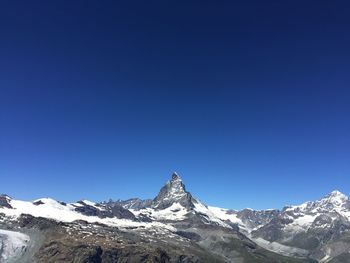 Snowcapped mountains against clear blue sky