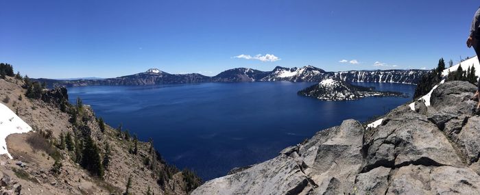 Panoramic view of sea and mountains against clear blue sky