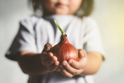 Midsection of girl holding onion
