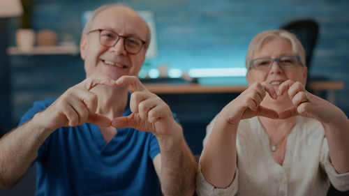 Portrait of senior couple making heart shape