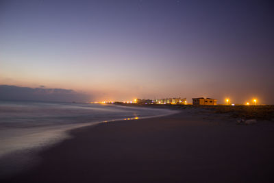 Scenic view of beach against sky at dusk