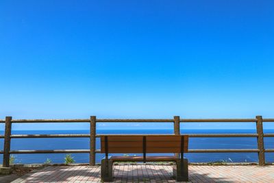 Pier over sea against clear blue sky