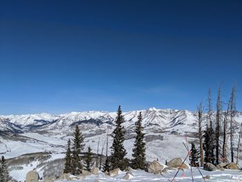 Snow covered landscape against blue sky