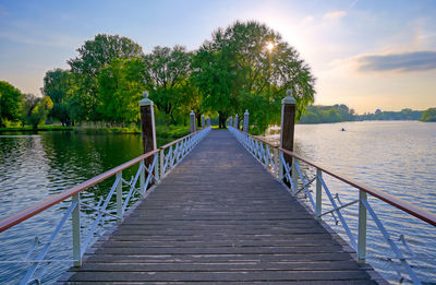 View of wooden bridge over calm lake