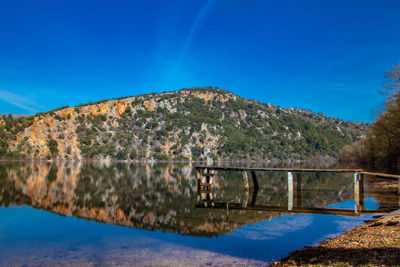 Bridge over mountain against blue sky