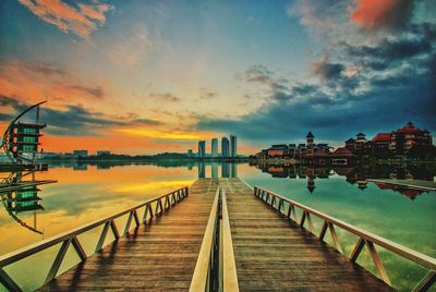 Pier in city at sunset