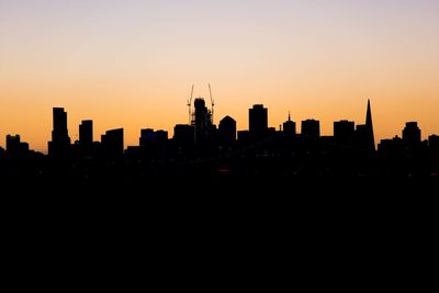 Silhouette cityscape against sky during sunset