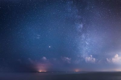 Scenic view of sea against star field at night