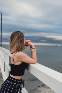 Rear view of woman photographing sea against sky