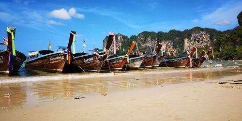 Boats moored on beach against sky