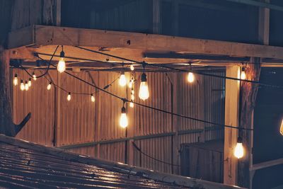 Low angle view of illuminated light bulbs at night