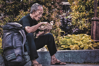 Side view of man sitting outdoors