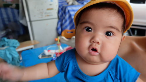 Close-up portrait of cute baby boy sitting at home