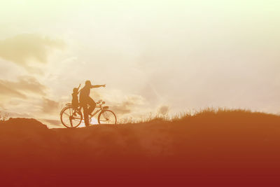 Silhouette man riding bicycle against sky during sunset