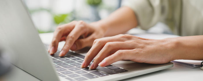 Midsection of woman using laptop