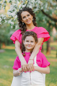 A young beautiful mom is happy and hugs her daughter, who is smiling