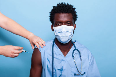 Cropped hand of doctor vaccinating patient in clinic