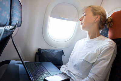 Tired businesswoman sleeping at airplane