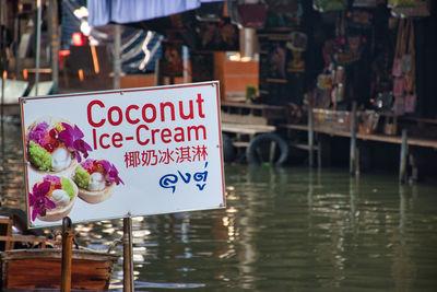 Close-up of information sign by canal