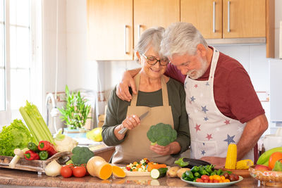 Senior couple preparing food at kitchen
