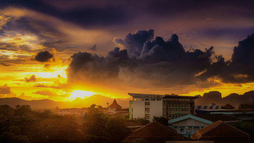 View of townscape against dramatic sky during sunset