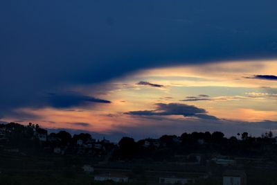 Silhouette buildings against sky at sunset