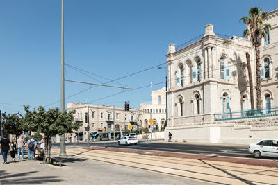 Cars on road in front of cathedral against clear sky