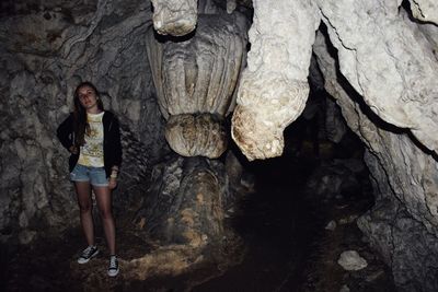 Portrait of woman standing on rock in cave