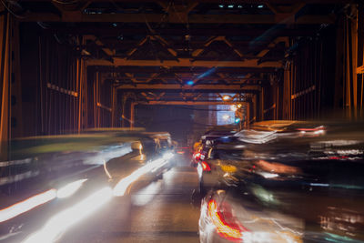 Blurred motion of cars on illuminated road in city