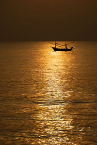 Silhouette boat in sea against sky during sunset