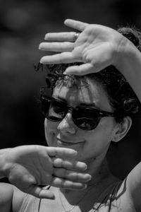 Close-up of smiling woman wearing sunglasses standing outdoors