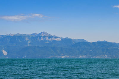 Scenic view of sea and mountains against sky