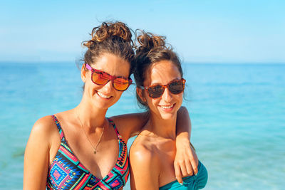 Portrait of smiling woman with sunglasses against sea