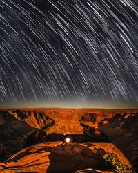 Scenic view of illuminated rock formation against sky at night