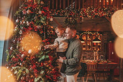 Smile little boy and dad having fun with each other hugs and kisses indoor waiting santa.