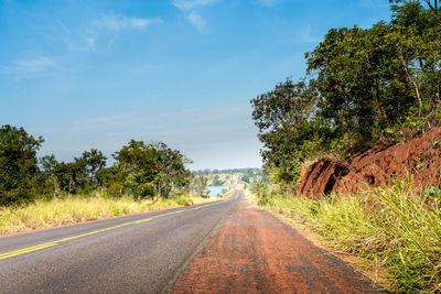 Road amidst trees against clear sky