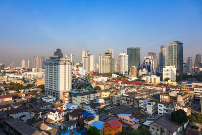 High angle view of modern buildings against blue sky