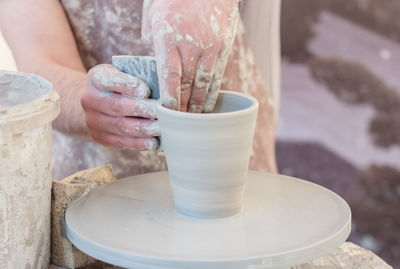 Midsection of man making pottery