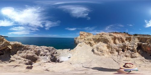 Rock formations on beach against sky