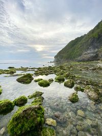 Scenic view of rocks in sea against sky