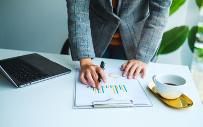 Businesswoman working on financial paperwork and laptop computer in office