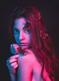 Portrait of beautiful woman against black background