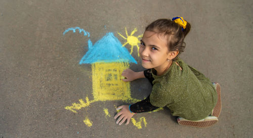 High angle view of young woman standing against wall