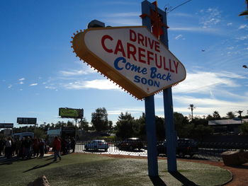 Information sign on road against blue sky