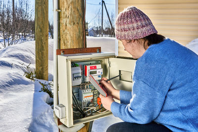 Rear view of man working on snow